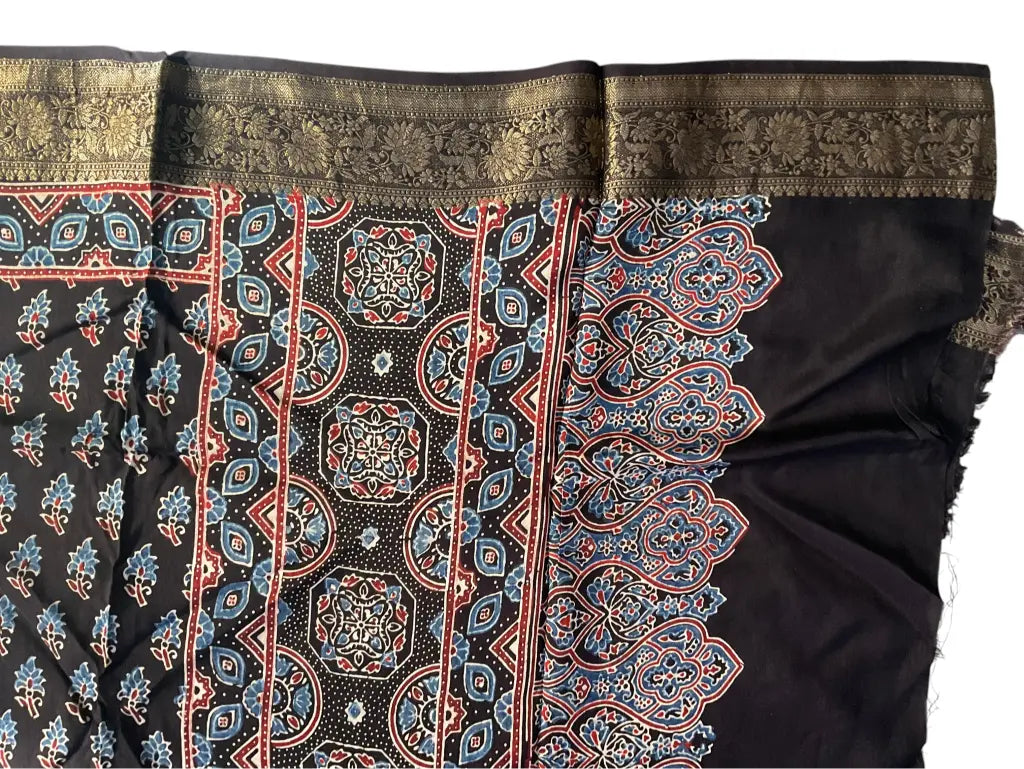 Close-up of rust buti & medallion pallu Ajrakh hand block print and gold zari border on black dola silk