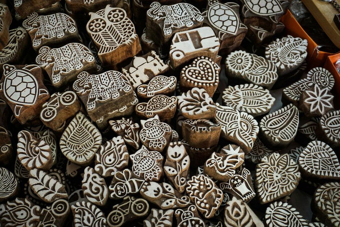 A pile of hand-carved wooden printing blocks with animal and floral motifs, used for Indian hand block printing