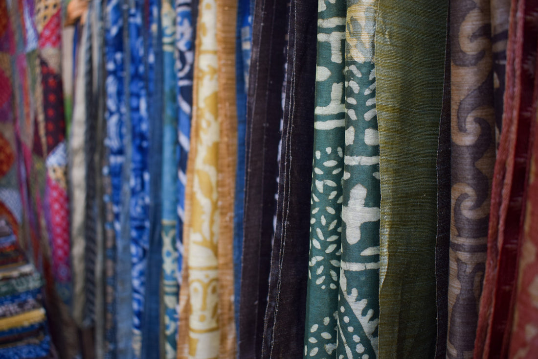 Colourful hand block printed fabrics hanging in a row in a market in Delhi, India