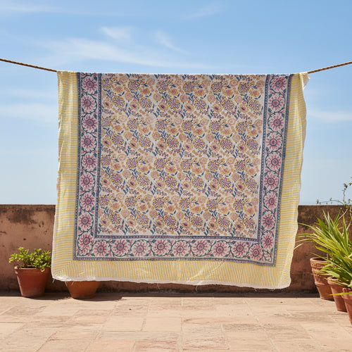Floral patterned fabric with a yellow border on a white background
