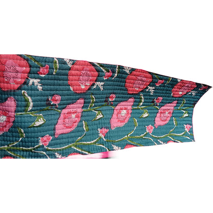 Floral patterned quilt with pink flowers on a teal background