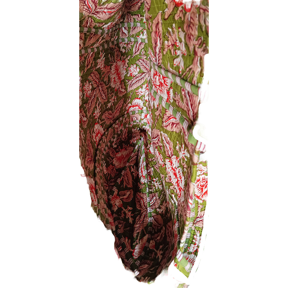 Traditional patterned fabric with green, red, and white colors on a white background