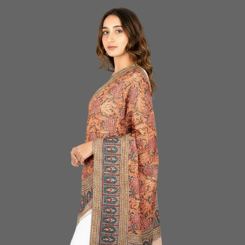 Woman wearing a patterned dress with a long scarf on a gray background