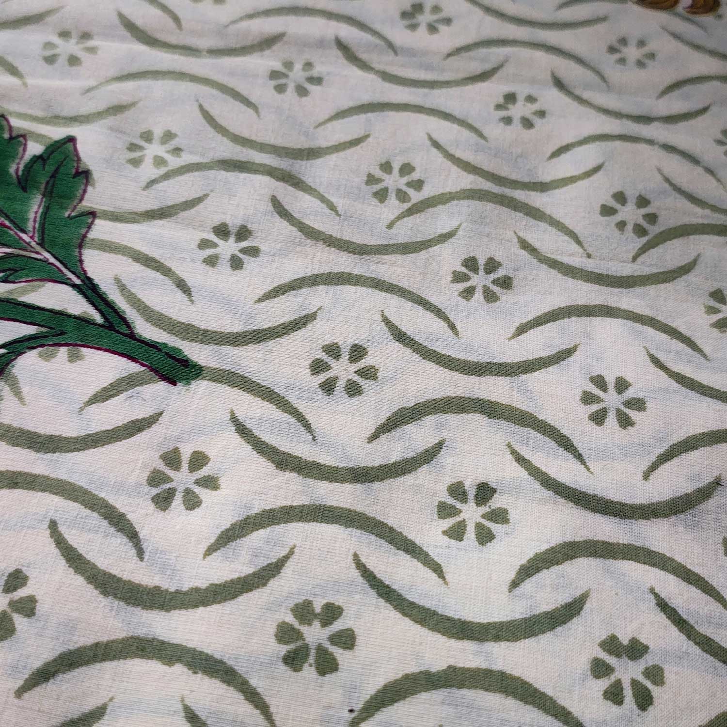 Textile with green floral and leaf pattern on a light background