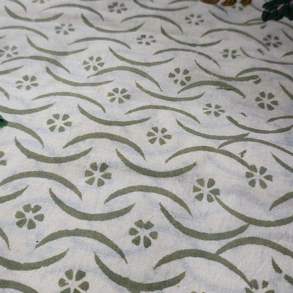Textile with green floral and wave pattern on a white background