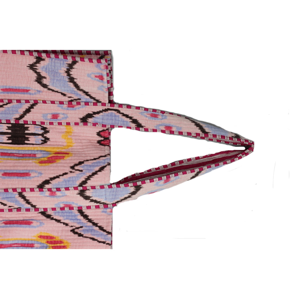 Close-up of a pink woven fabric with geometric patterns on a white background