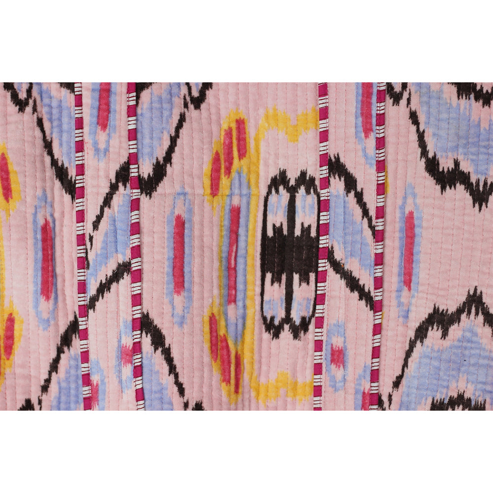 Close-up of a colorful patterned fabric with pink background