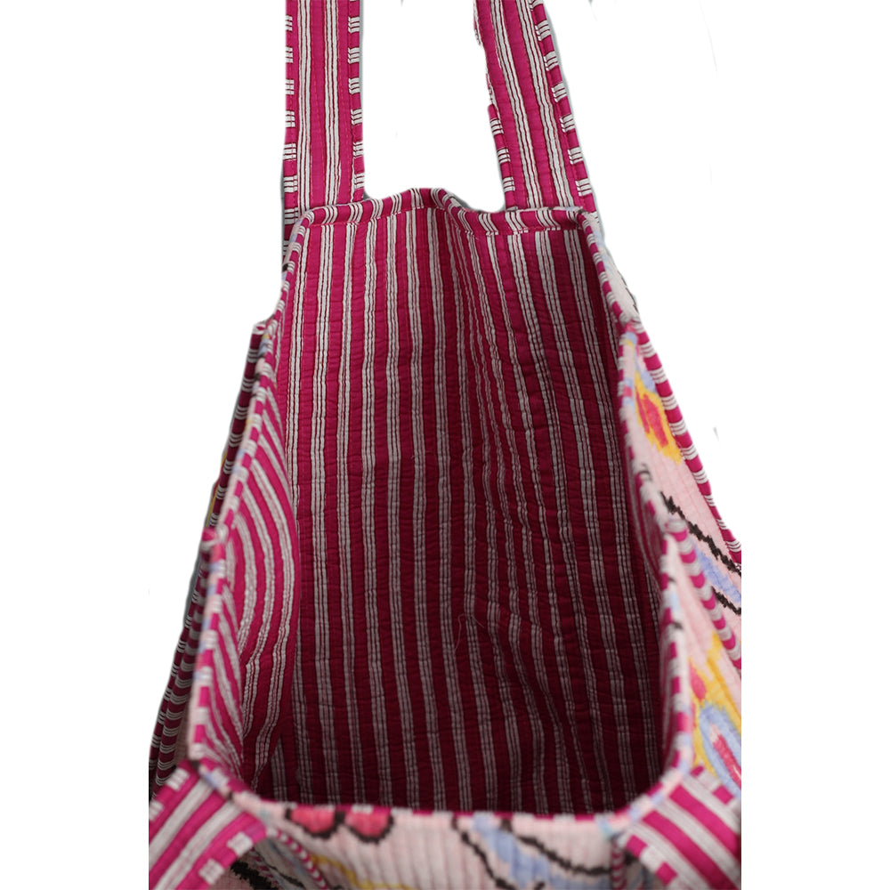 Close-up of a fabric bag with pink and brown pattern on a white background