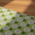 Close-up of green fabric with circular pattern on a blurred background
