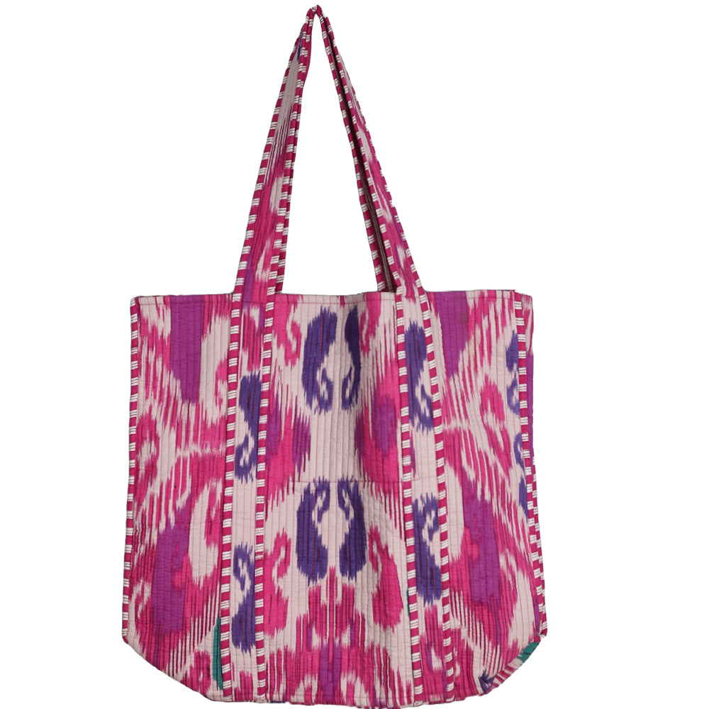 Pink and purple patterned bag with a strap on a white background
