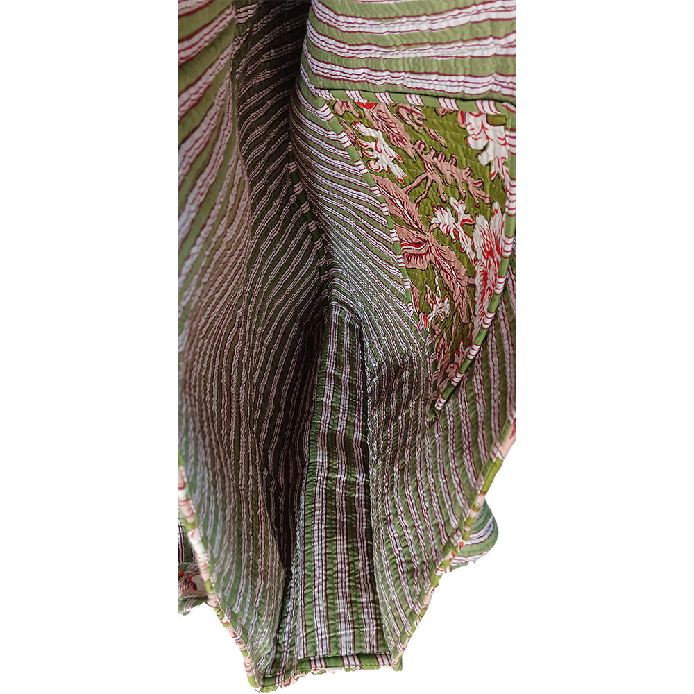 Close-up of a green and pink patterned fabric with a white background