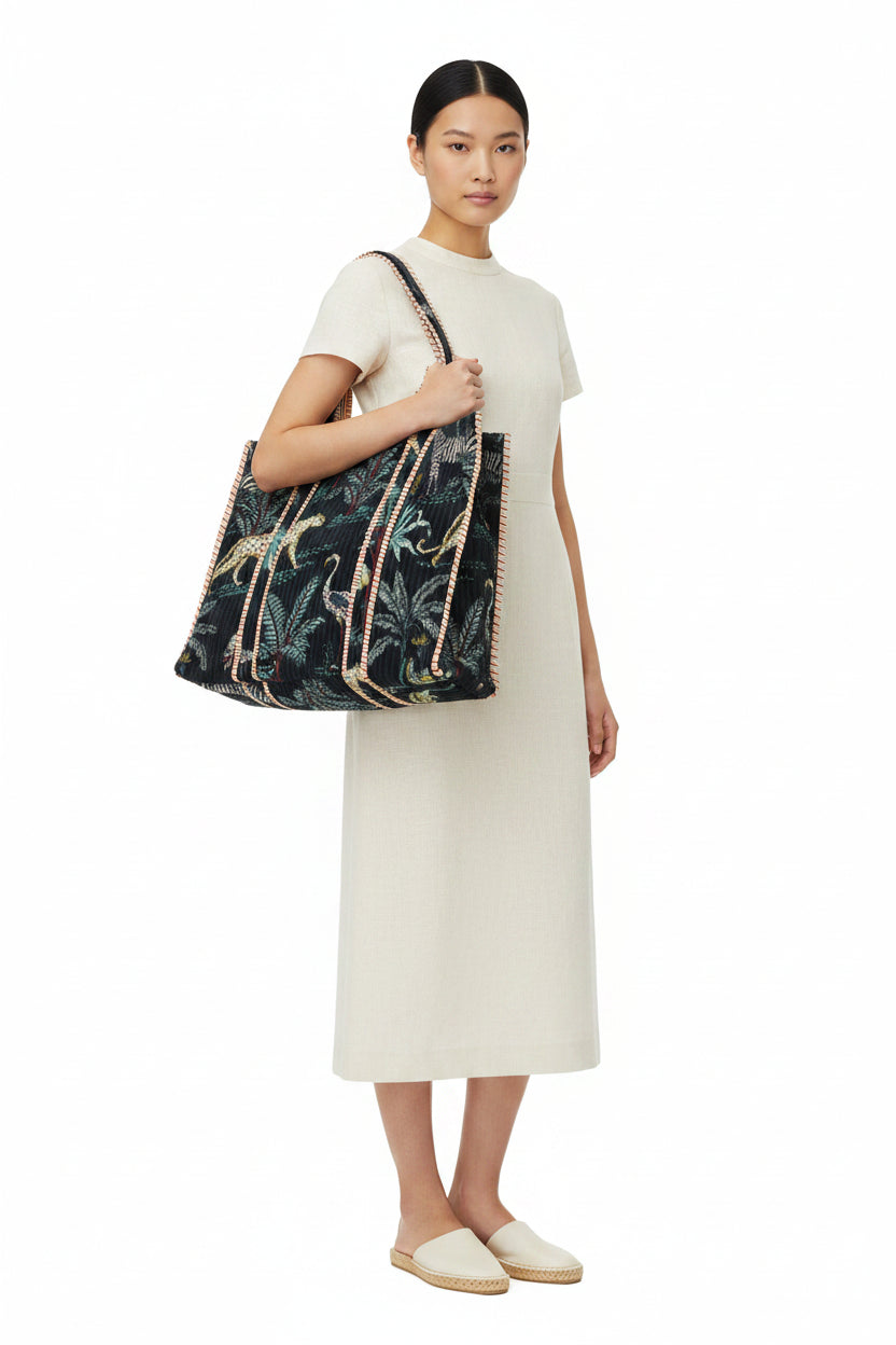Woman holding a large floral-patterned bag against a white background