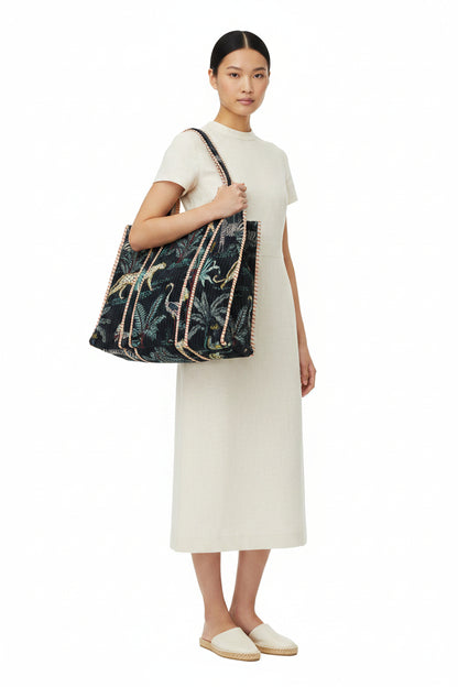 Woman holding a large floral-patterned bag against a white background