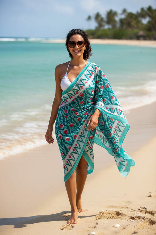 Woman on a beach wearing a green and white patterned sarong