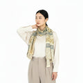 Woman wearing a patterned scarf on a white background