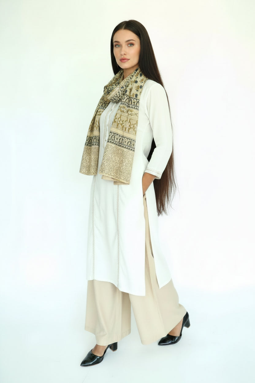 Woman wearing a black outfit with a patterned scarf on a white background