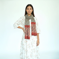 Woman wearing a floral dress and patterned scarf on a white background