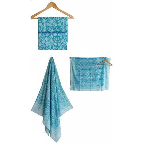 Set of blue patterned towels on wooden hangers against a white background
