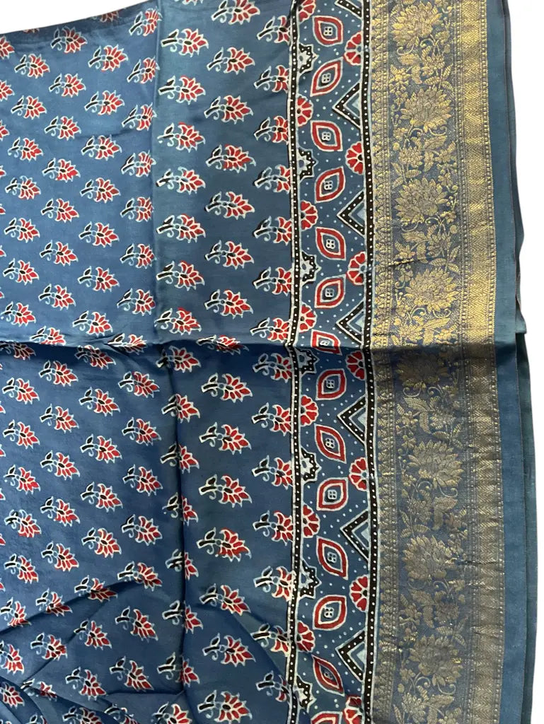 Close-up of red buti Ajrakh hand block print and gold zari border on steel blue dola silk