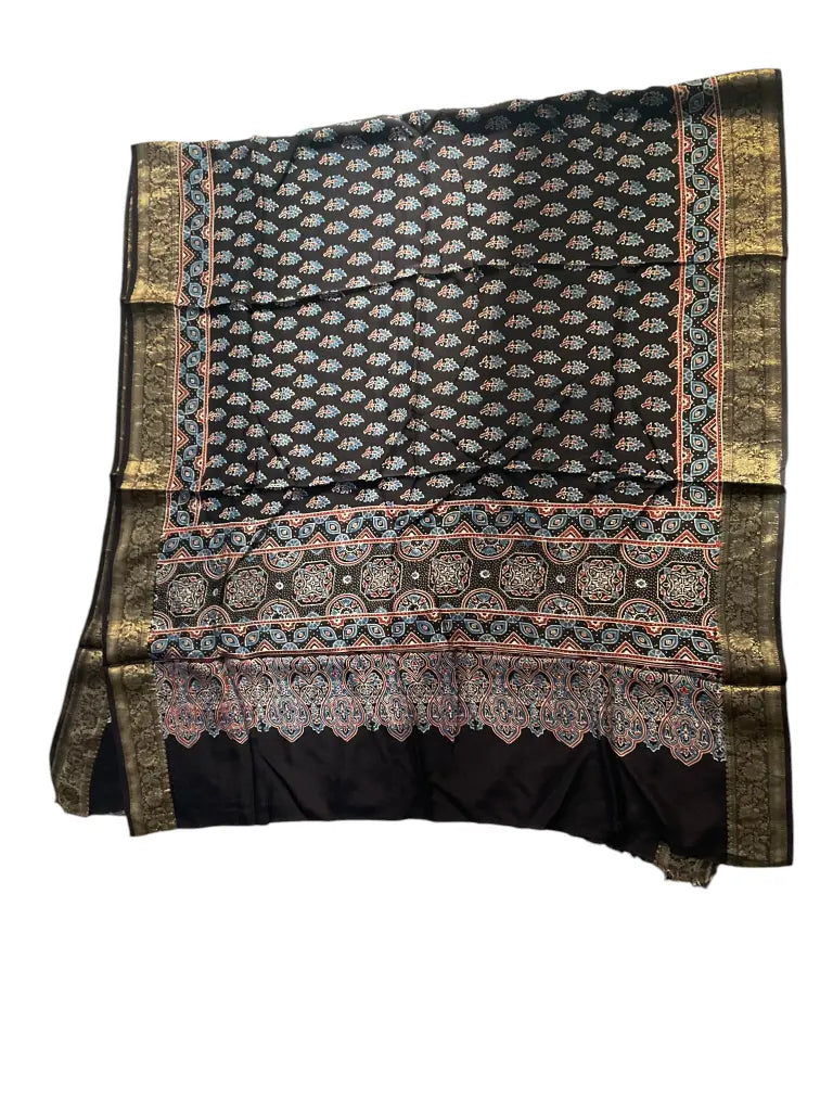 Black hand block printed Ajrakh dupatta laid flat showing rust buti & medallion pallu print, pallu and zari border
