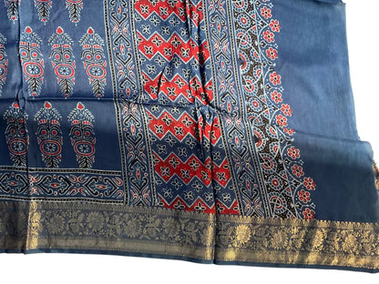 Close-up of cypress booti Ajrakh hand block print and gold zari border on indigo blue & red dola silk
