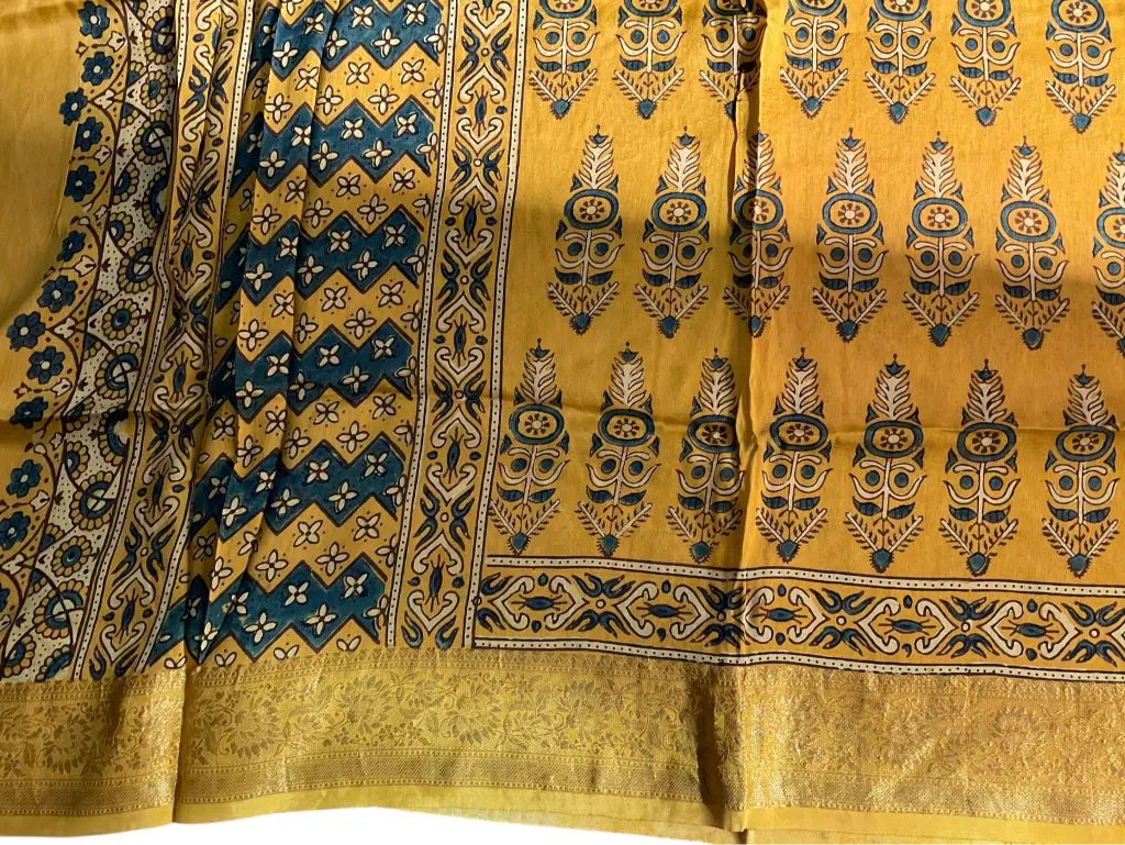 Close-up of cypress booti Ajrakh hand block print and gold zari border on turmeric yellow & teal dola silk