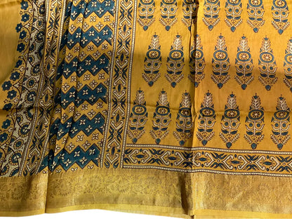 Close-up of cypress booti Ajrakh hand block print and gold zari border on turmeric yellow & teal dola silk