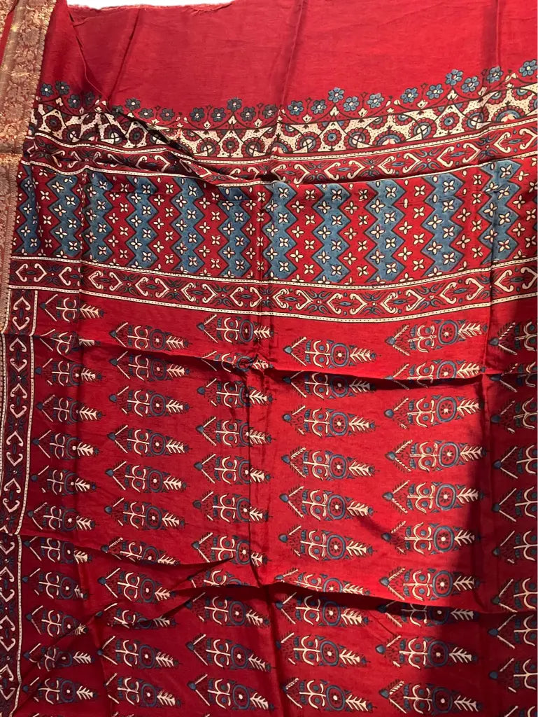 Close-up of cypress booti Ajrakh hand block print and gold zari border on madder red & indigo dola silk