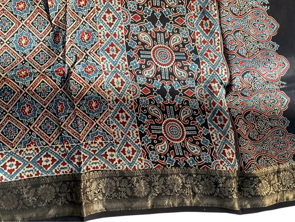 Close-up of diamond jaal Ajrakh hand block print and gold zari border on black & madder red dola silk
