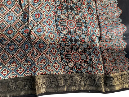 Close-up of diamond jaal Ajrakh hand block print and gold zari border on black & madder red dola silk