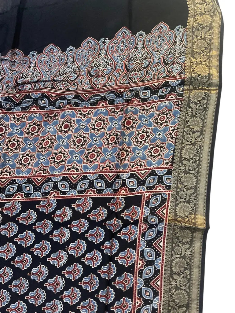Close-up of paisley buti Ajrakh hand block print and gold zari border on black & rose dola silk