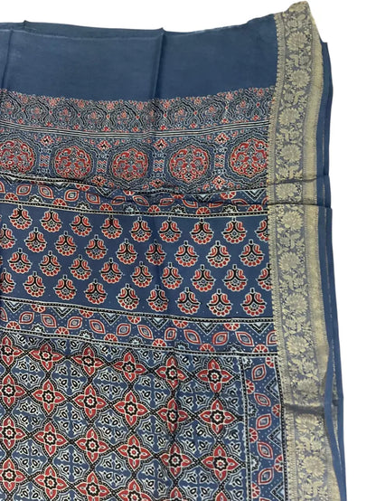 Close-up of floral buti Ajrakh hand block print and silver-toned zari border on indigo & rust dola silk
