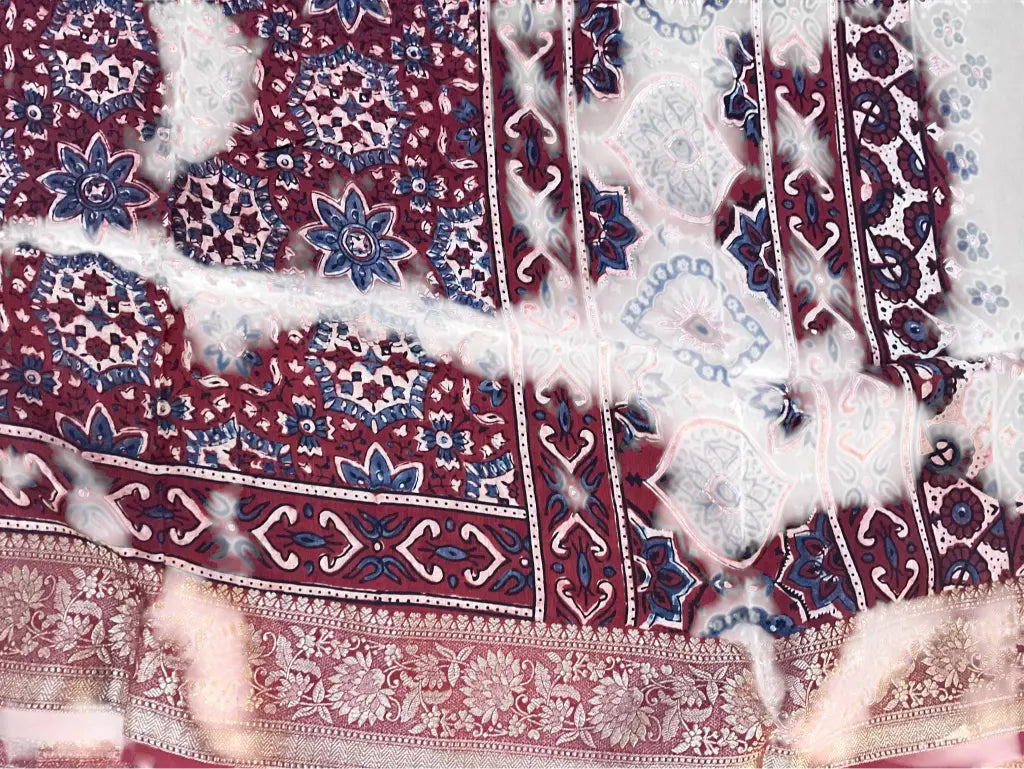 Close-up of medallion jaal Ajrakh hand block print and gold zari border on wine maroon dola silk