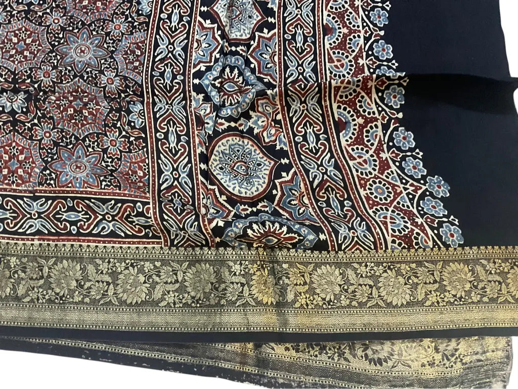Close-up of medallion jaal Ajrakh hand block print and gold zari border on charcoal black & red dola silk
