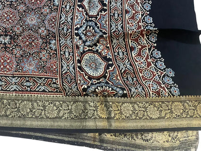 Close-up of medallion jaal Ajrakh hand block print and gold zari border on charcoal black & red dola silk